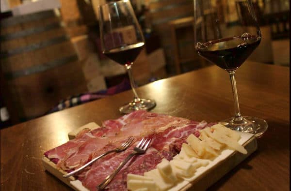 What to do in Montepulciano - Tuscan wine shop - Platter of cured meats and cheeses - glasses of wine