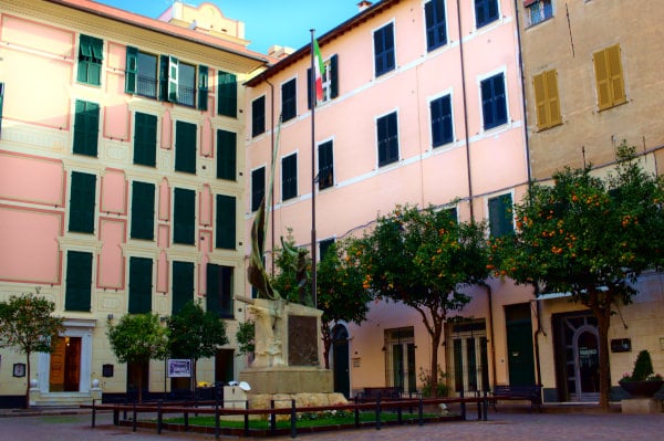 What to see in Laigueglia - Historic centre - Piazza della Libertà - trees - Pink buildings